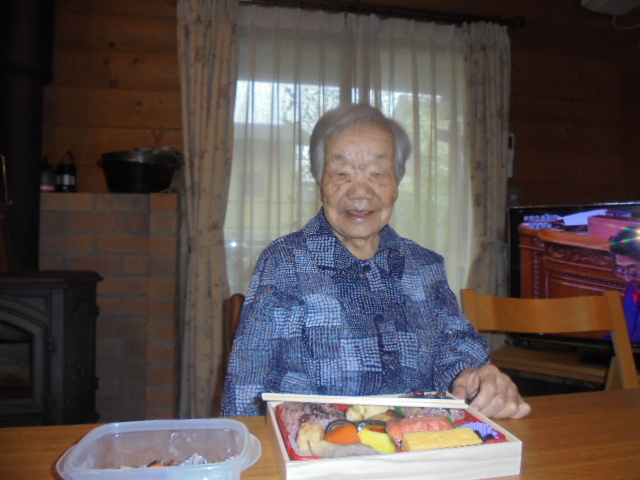 入居者が食事や弁当を前にした日常風景。木造の温かみある居室内での生活シーン。